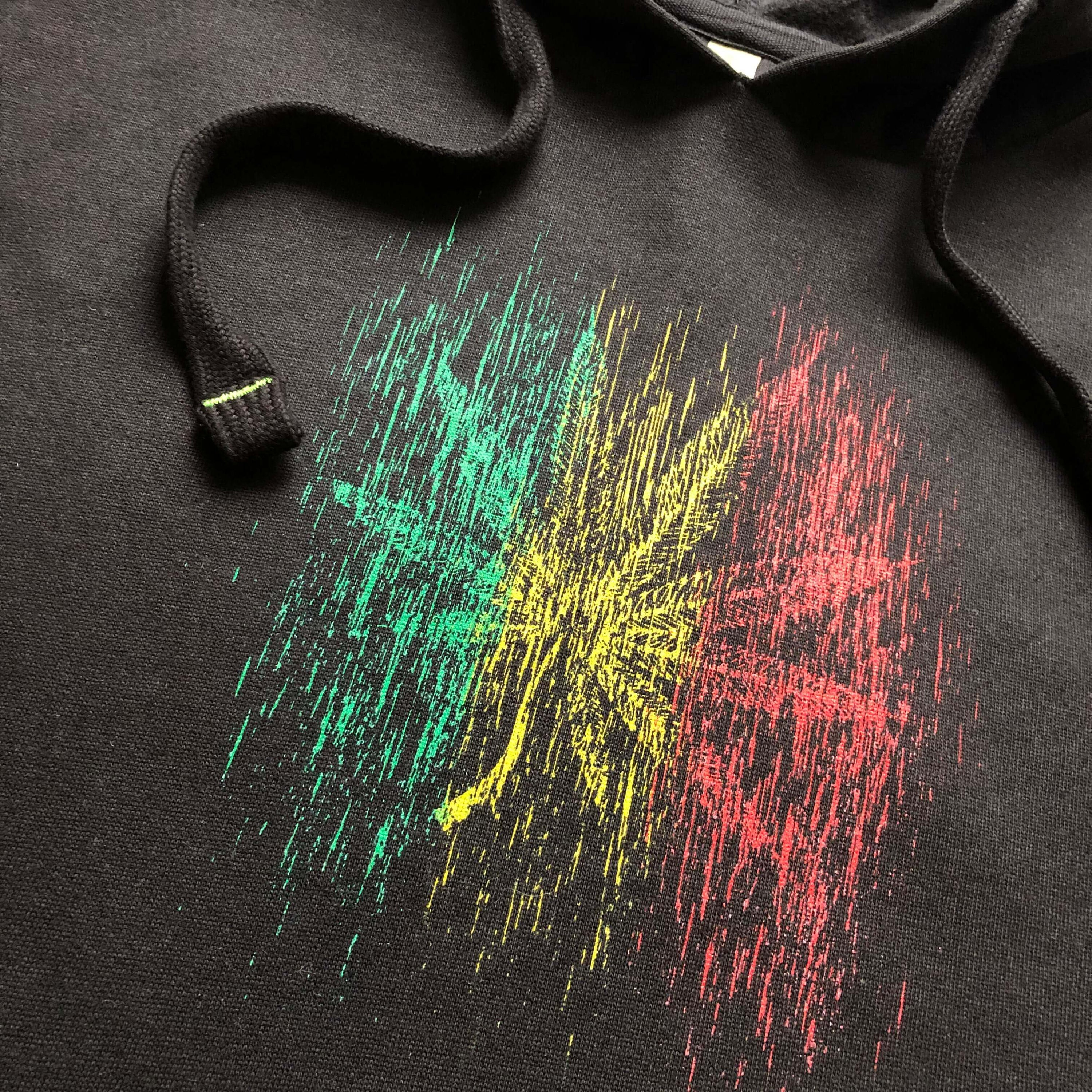 Black hoodie with a rasta color rainy effect hemp leaf graphic