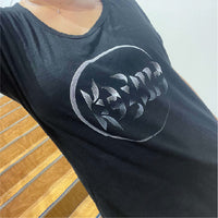 Woman wearing a black t-shirt with a karma design.