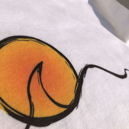 Close-up of a white crop t-shirt with a sunset design.