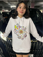 A girl wearing white hoodie with a colorful flower design.